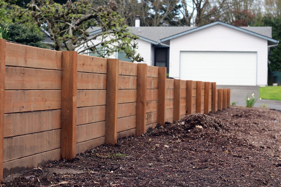 Timber sleeper retaining wall with timber posts beside a Dapto home