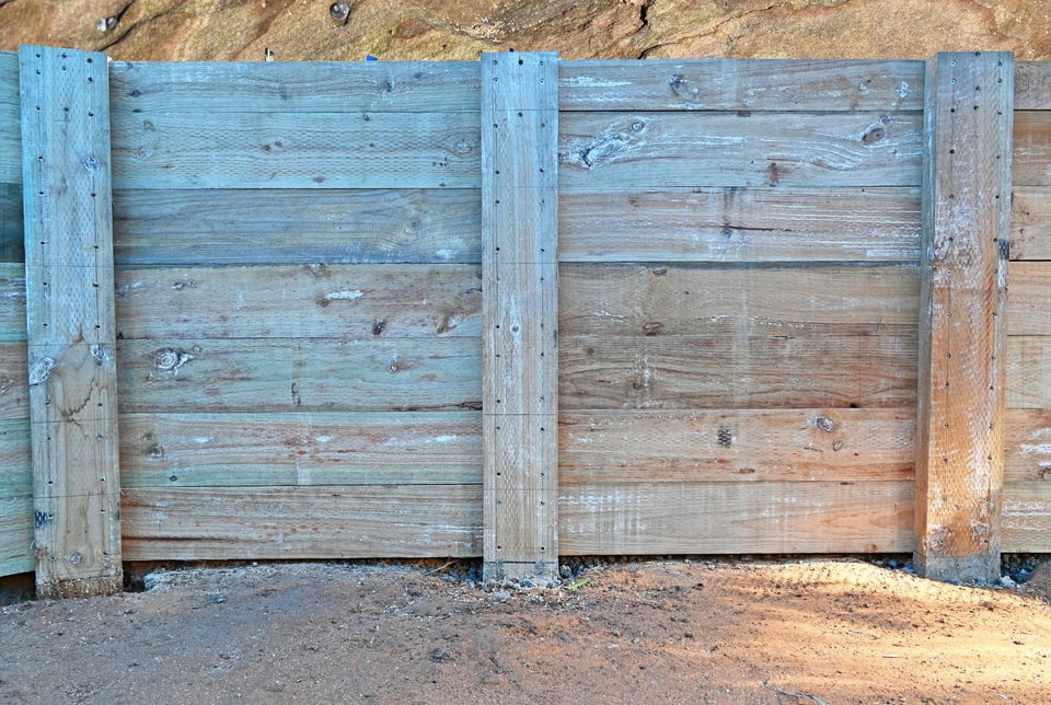 Treated timber sleeper retaining wall with timber posts against sandstone in Stanwell Park