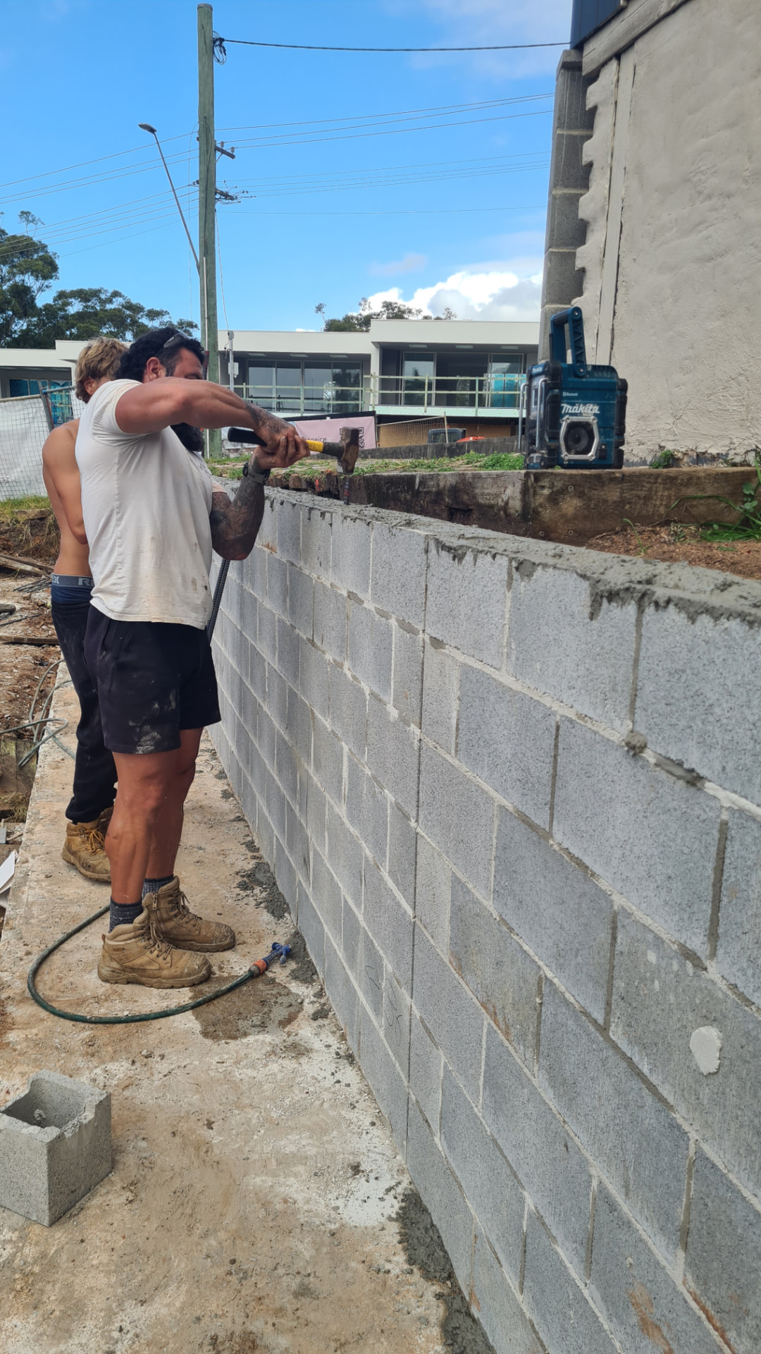 Retain by Theo team laying a besser block retaining wall on a Wollongong site